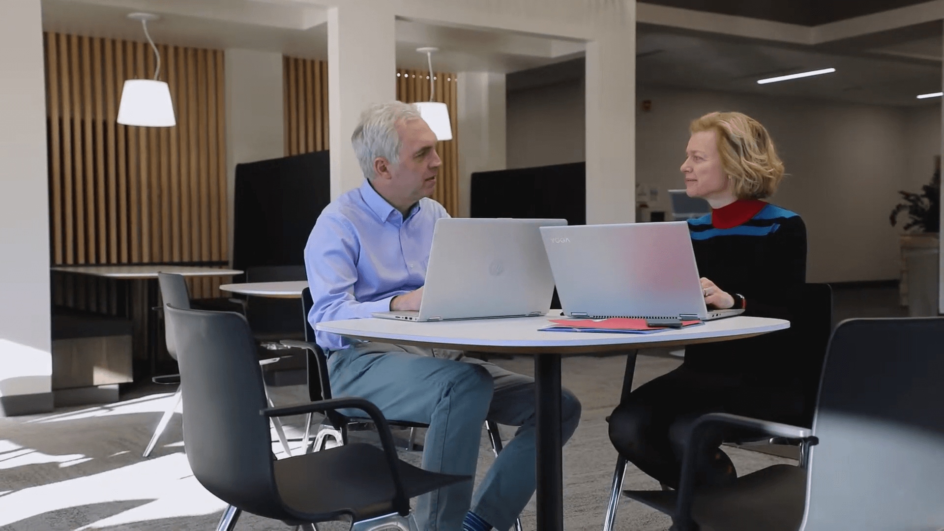 Jeffrey Jensen Arnett & Lene Arnett Jensen conversing with one another while working on laptops.