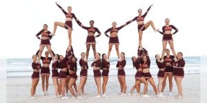 Blog author Caroline and her cheerleading team pose together on a beach.