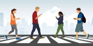 A graphic depicting four people walking in a crosswalk while looking at their phones.