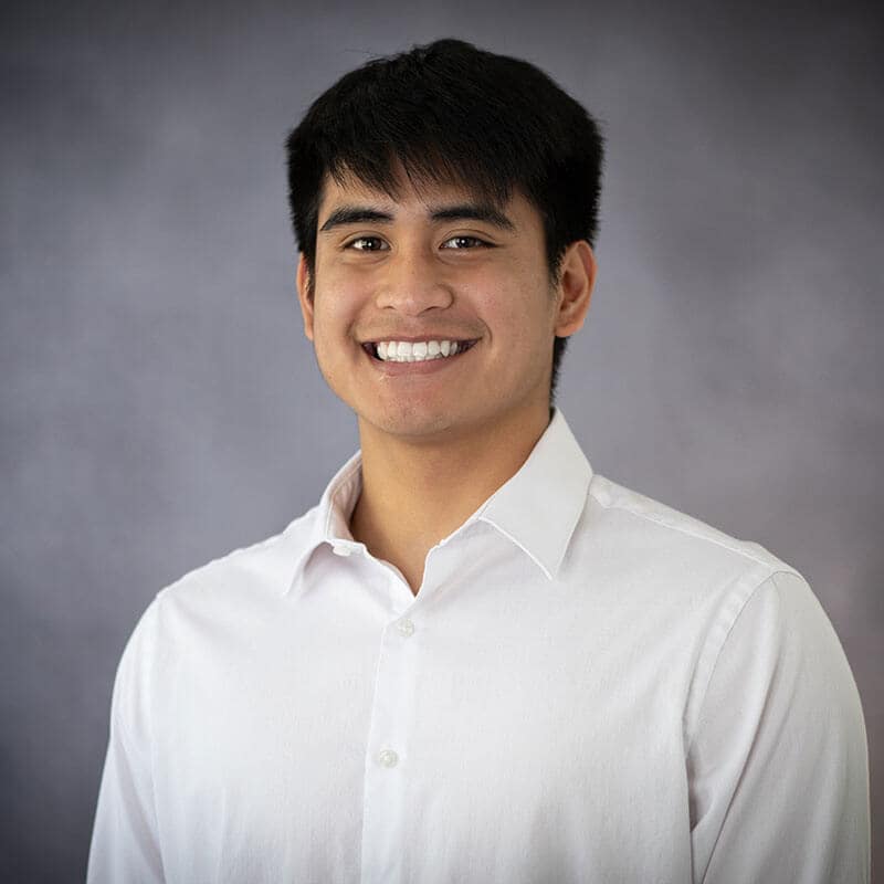 Studio headshot of blog author Jocel. He has short dark hair and is wearing a white button-down shirt.