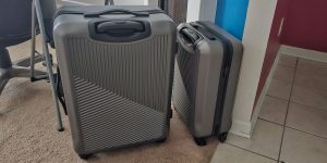 Two matching wheeled grey suitcases; one is a bit larger than the other.