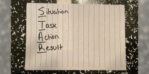 A lined notepaper paper listing the words ‘Situation’, ‘Task’, ‘Action’, ‘Result’.