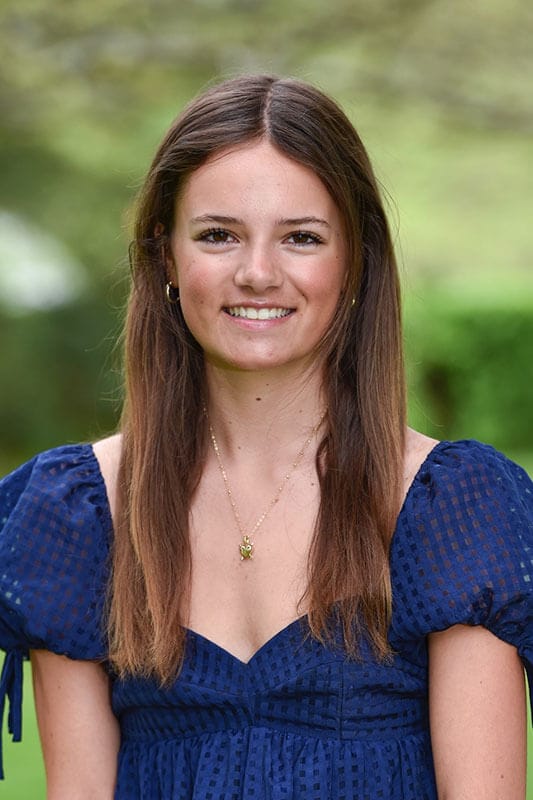 Blog author Whitney has long straight brown hair and is wearing a dark blue blouse with puffy sleeves.