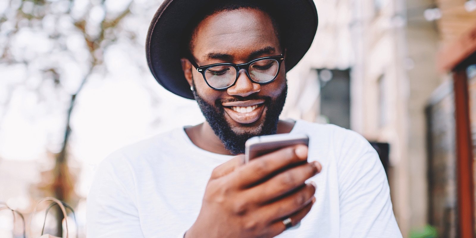 A man looking at his phone with a smile.