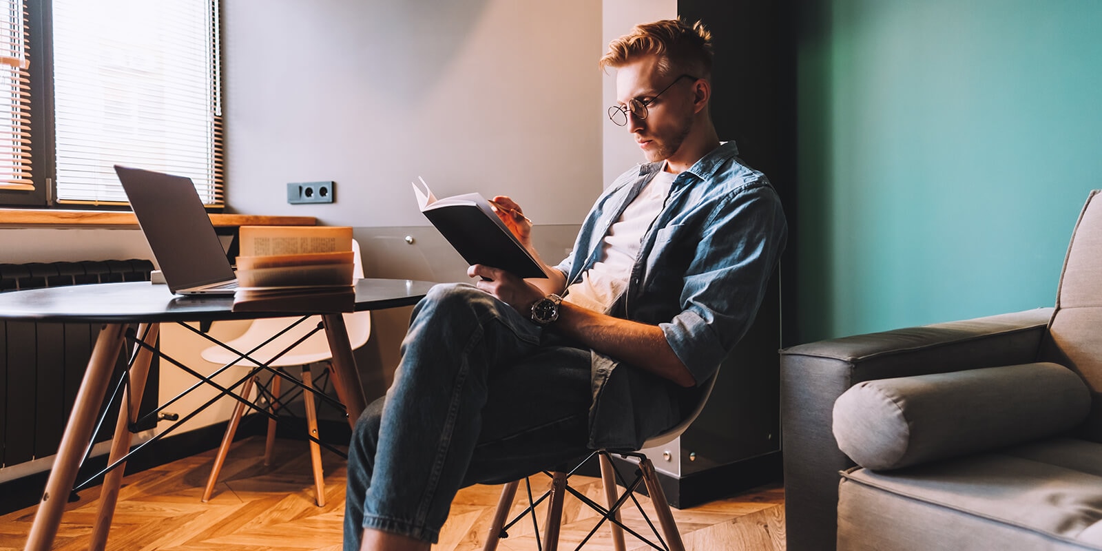 A man sitting in a chair and reading a book