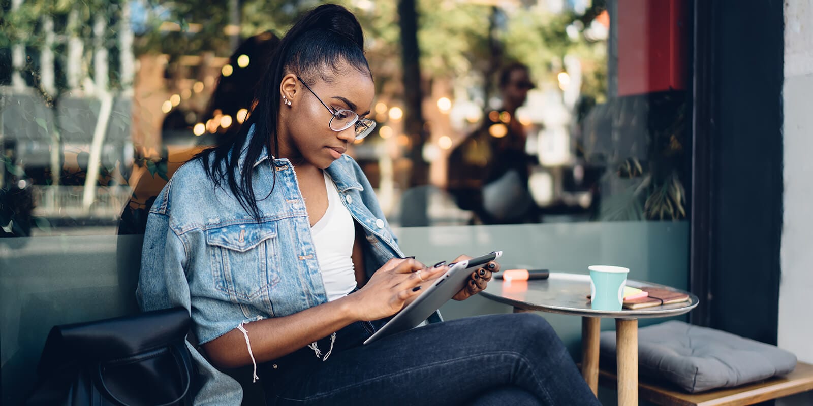 A woman working on a tablet sitting in a chair