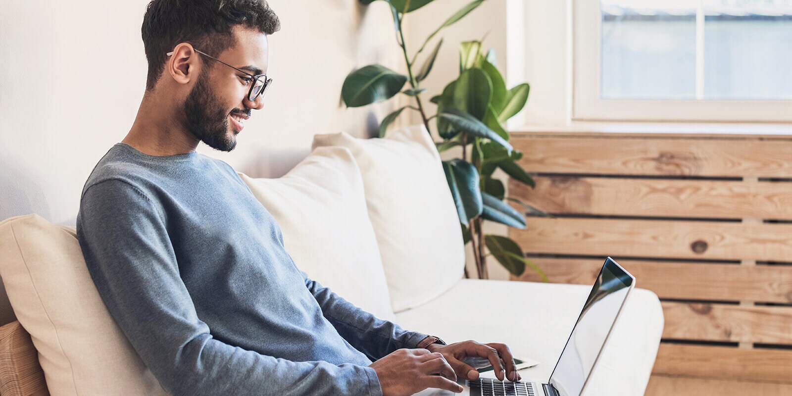 Man looking at computer sitting on a couch