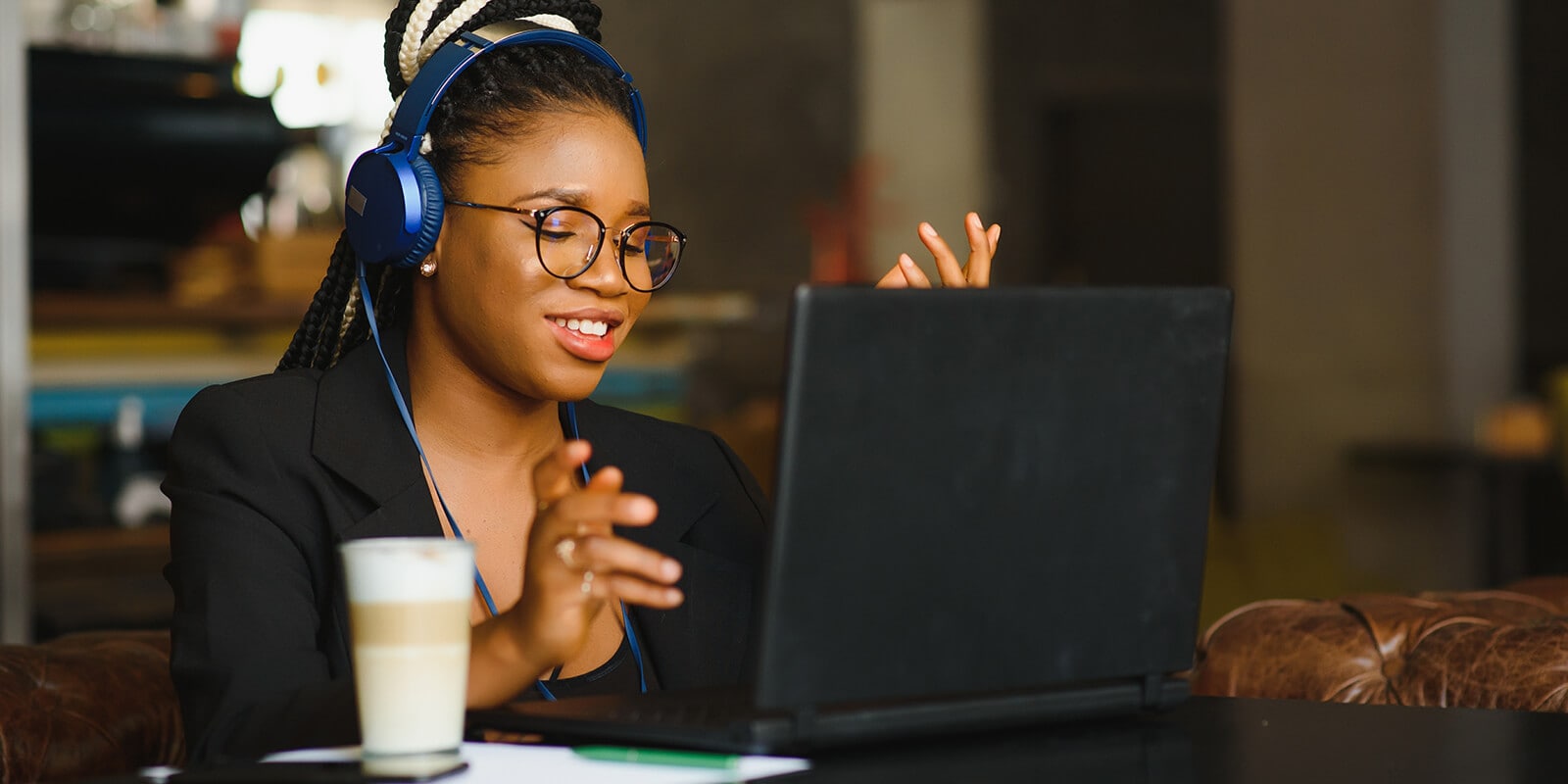Woman wearing headset, engaged in a conversation on her computer