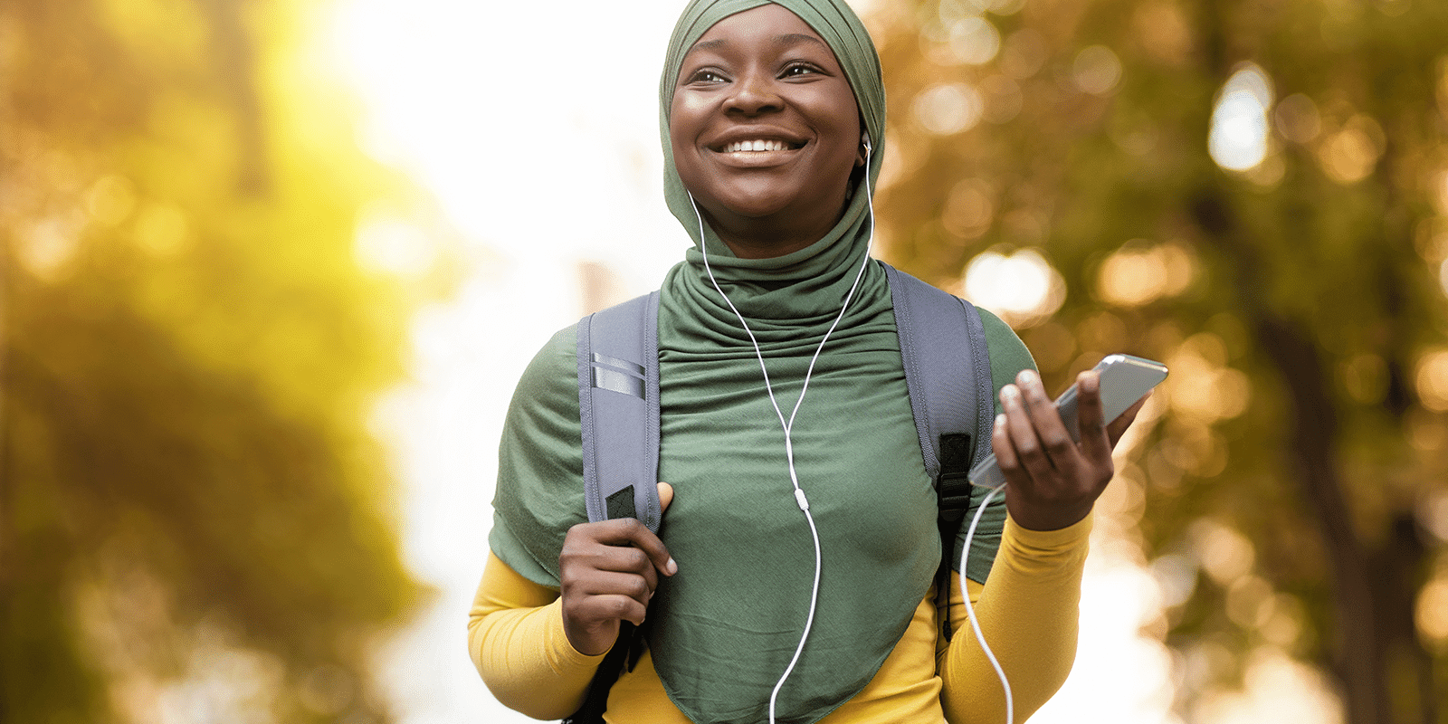 A young woman listening to phone with earphone on.