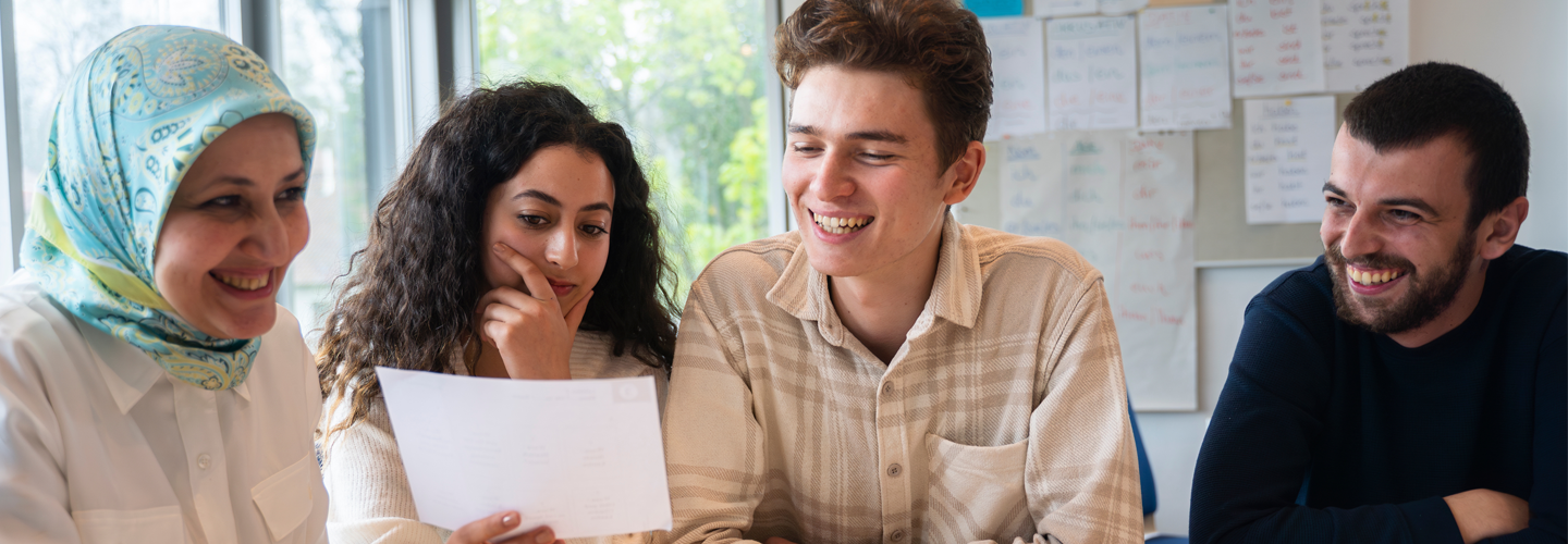 Students sat together looking at a paper