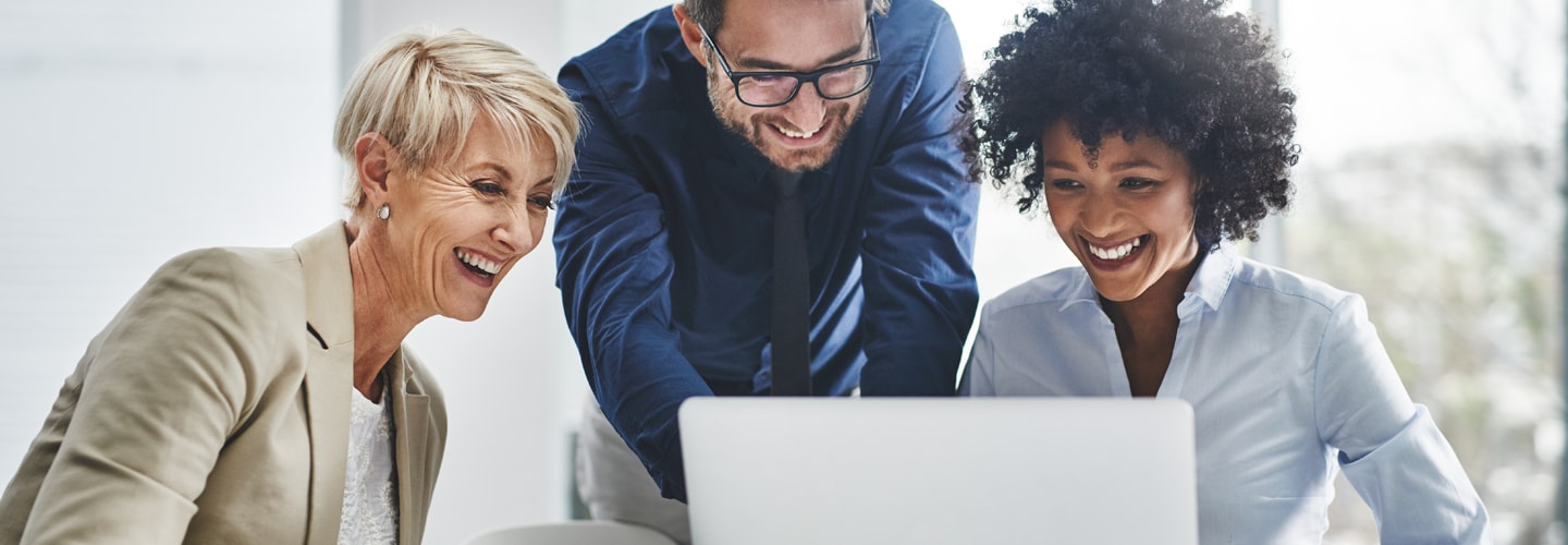 ビジネスマンは、ノートパソコンを囲んで笑顔で一緒に座っていました