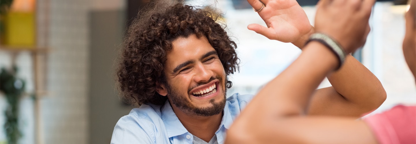 A man smiling and high fiving another person