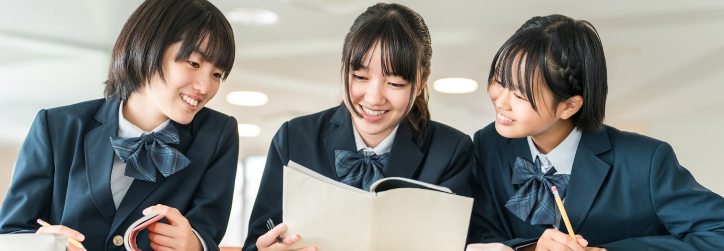 Students looking at notebooks smiling