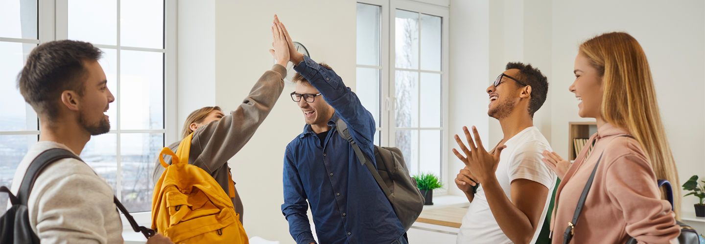 A group of students celebrating and high fiving eachother