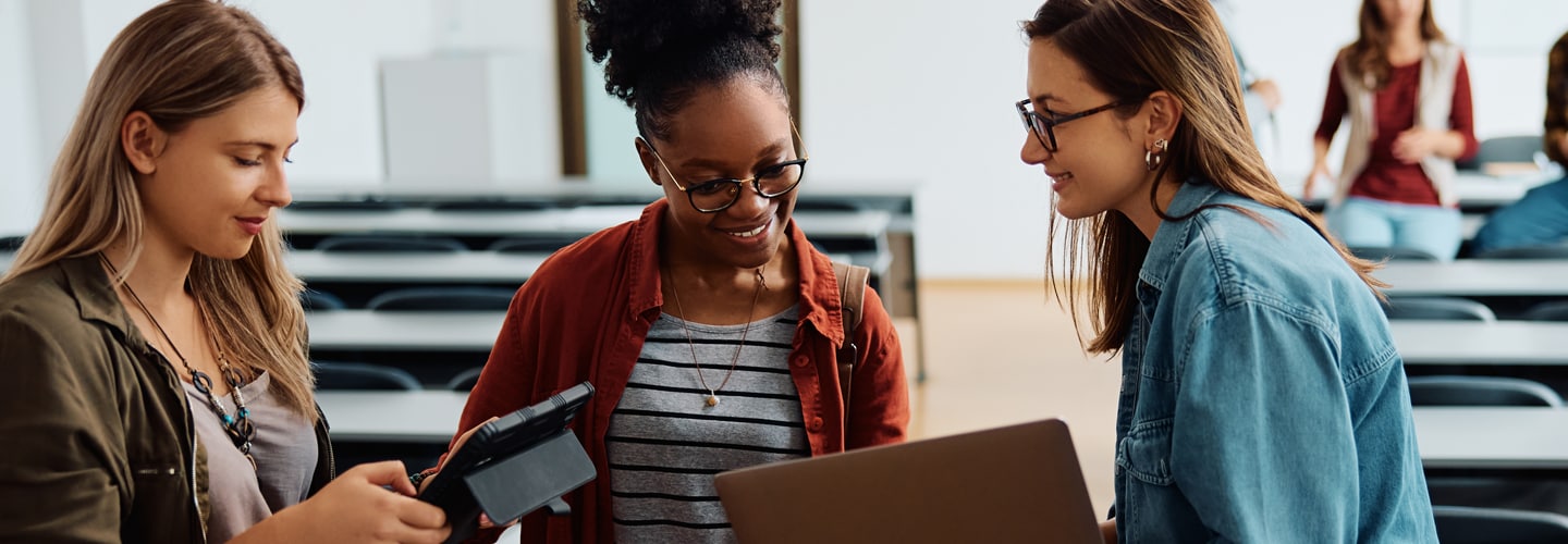 University students stood in a class together working on tablets