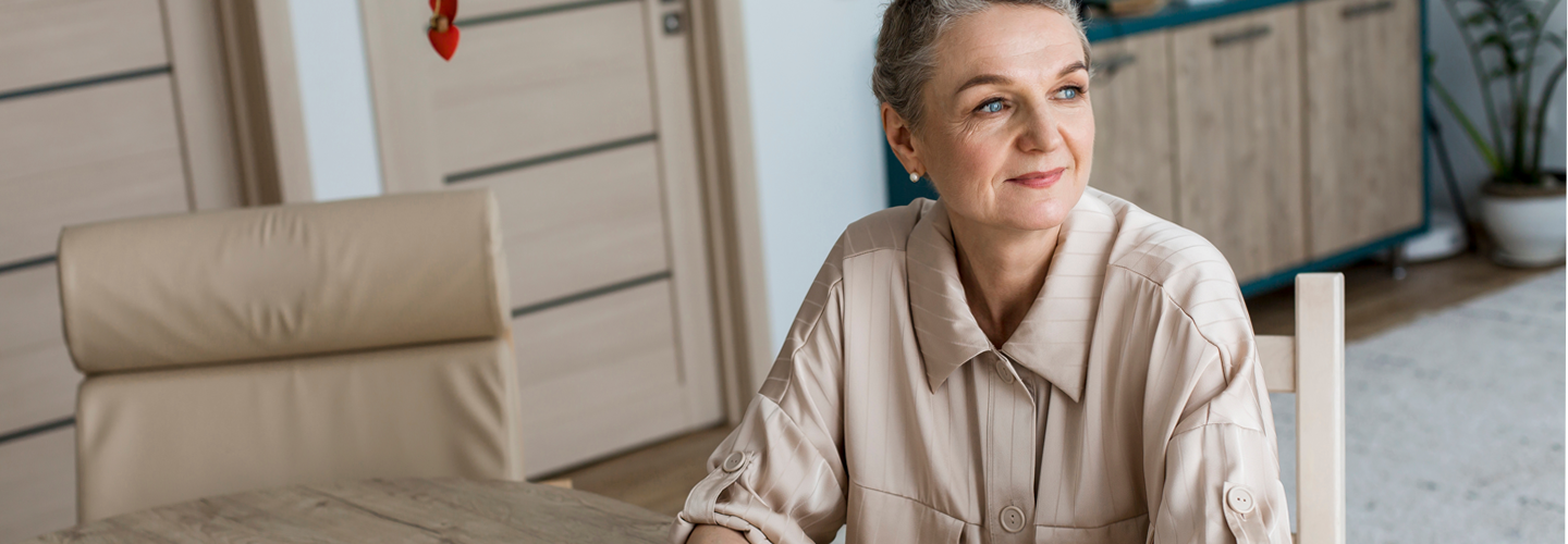 A woman sat at a table contemplating